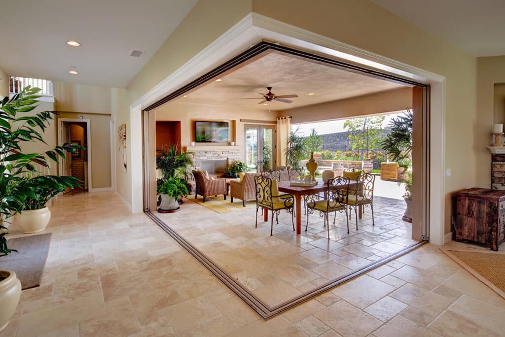 A pocketed 90-degree multi-slide glass door connects an outdoor living space to the indoors.