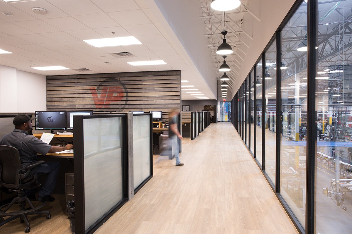 This window wall on the mezzanine level completely blocks the sound from the busy manufacturing floor below