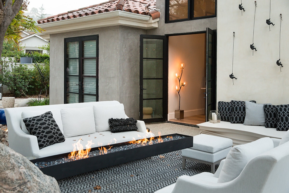 Two divided lights hinged doors open to connect the outdoor seating area to the indoors.