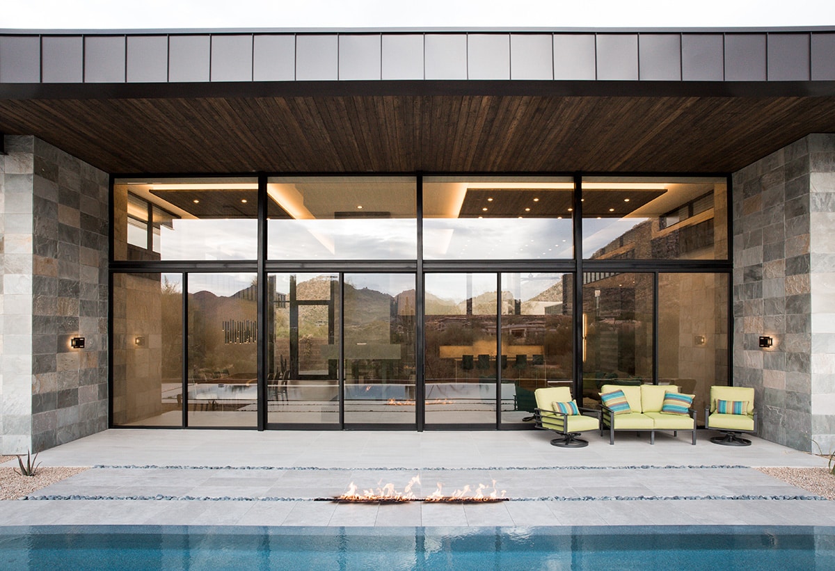 Much of the home’s interior can be seen through the moving walls of glass in the backyard.
