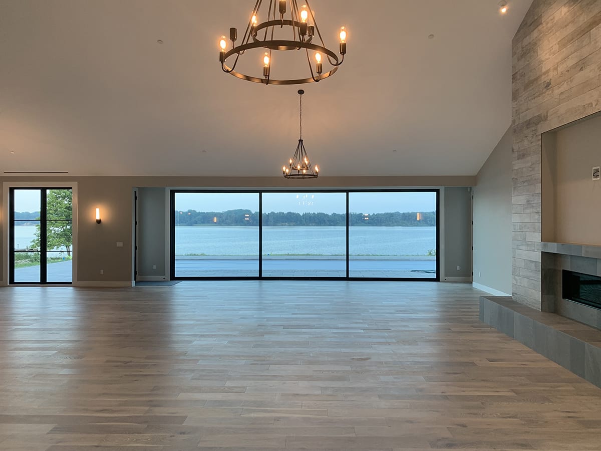 Moving walls of glass open the living space of the home to the shoreline outside.