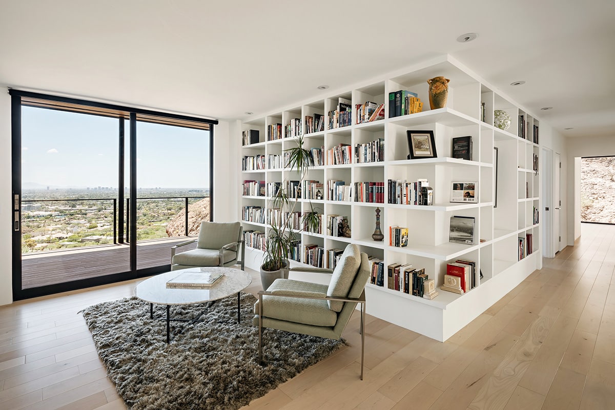 The large multi-slide door in a sitting area connects to an outdoor patio with a great view of the Phoenix skyline in the distance.