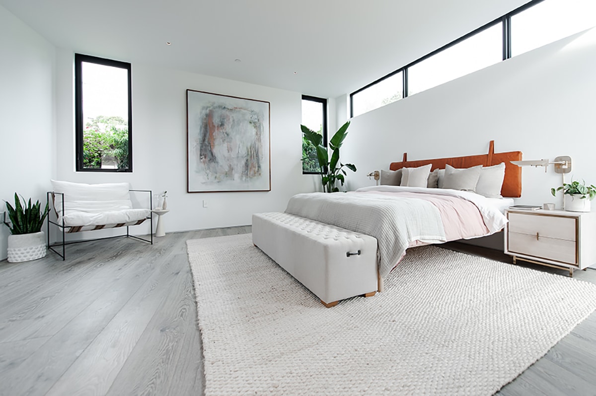 A bedroom with clerestory windows above the bed and hinged windows in the corners.