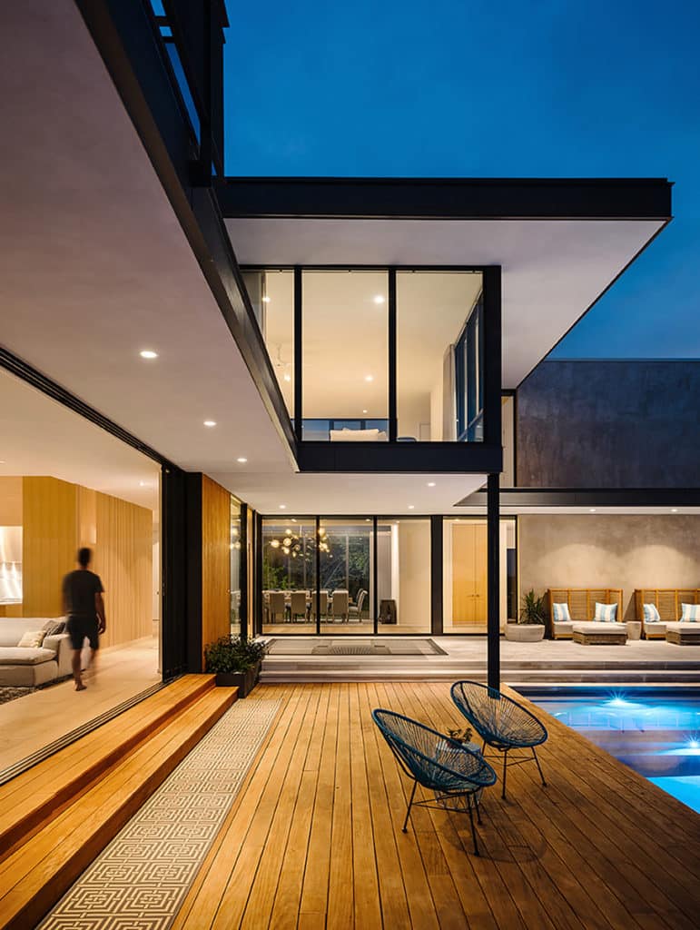 Floor-to-ceiling glass opens an entire wall of the home to the primary outdoor space.