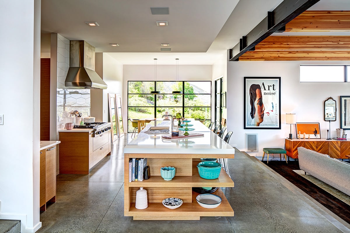 A large, fixed window brings natural light into the dining area and kitchen.