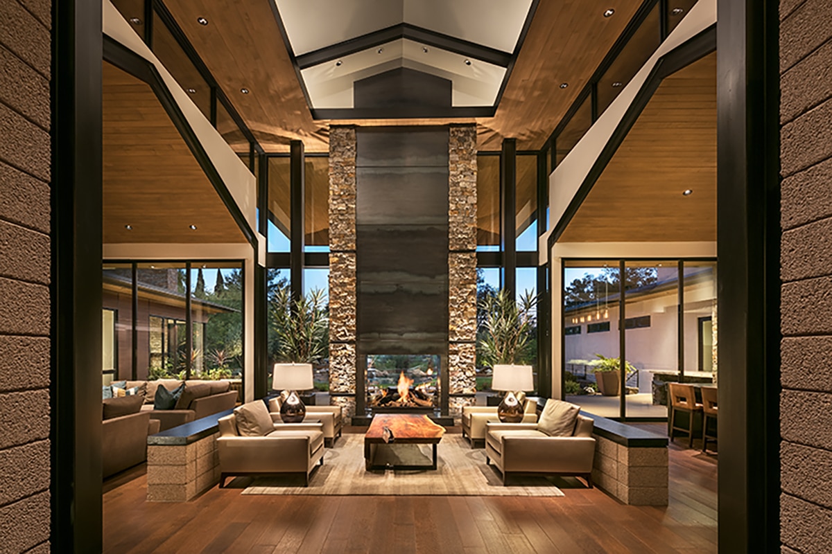 A view from the entryway of the great room with a fireplace and nearly all glass walls.