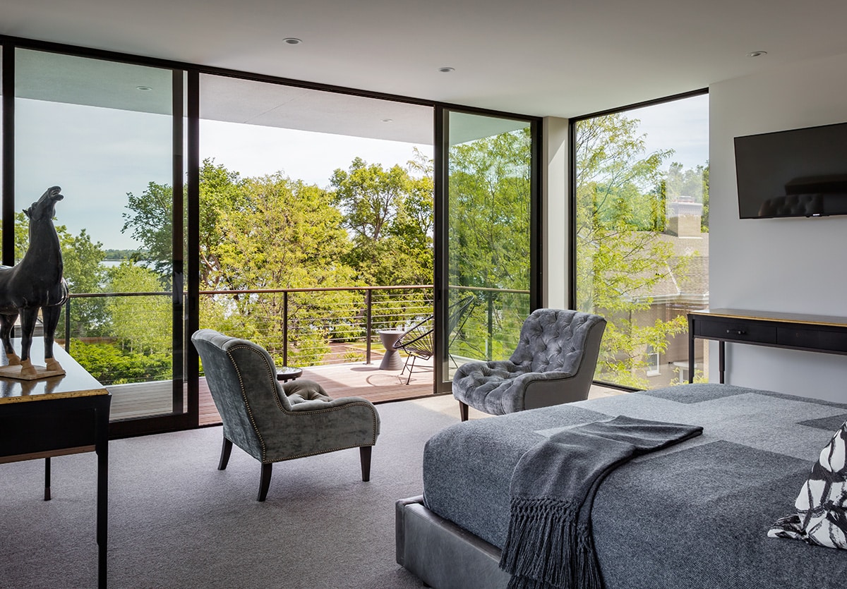Large, bi-parting sliding glass doors connect the master bedroom to a balcony.