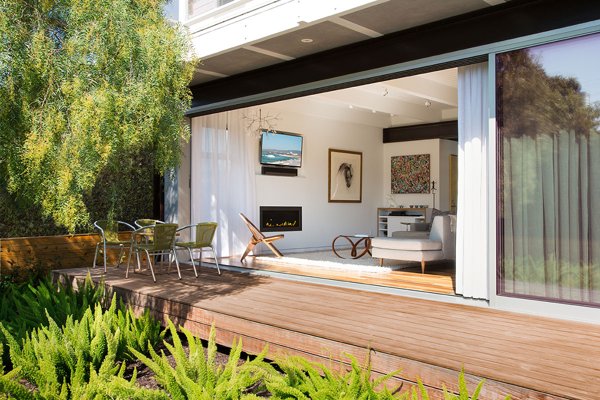 The open, multi-slide glass door creates an invisible wall between the inside and outside.
