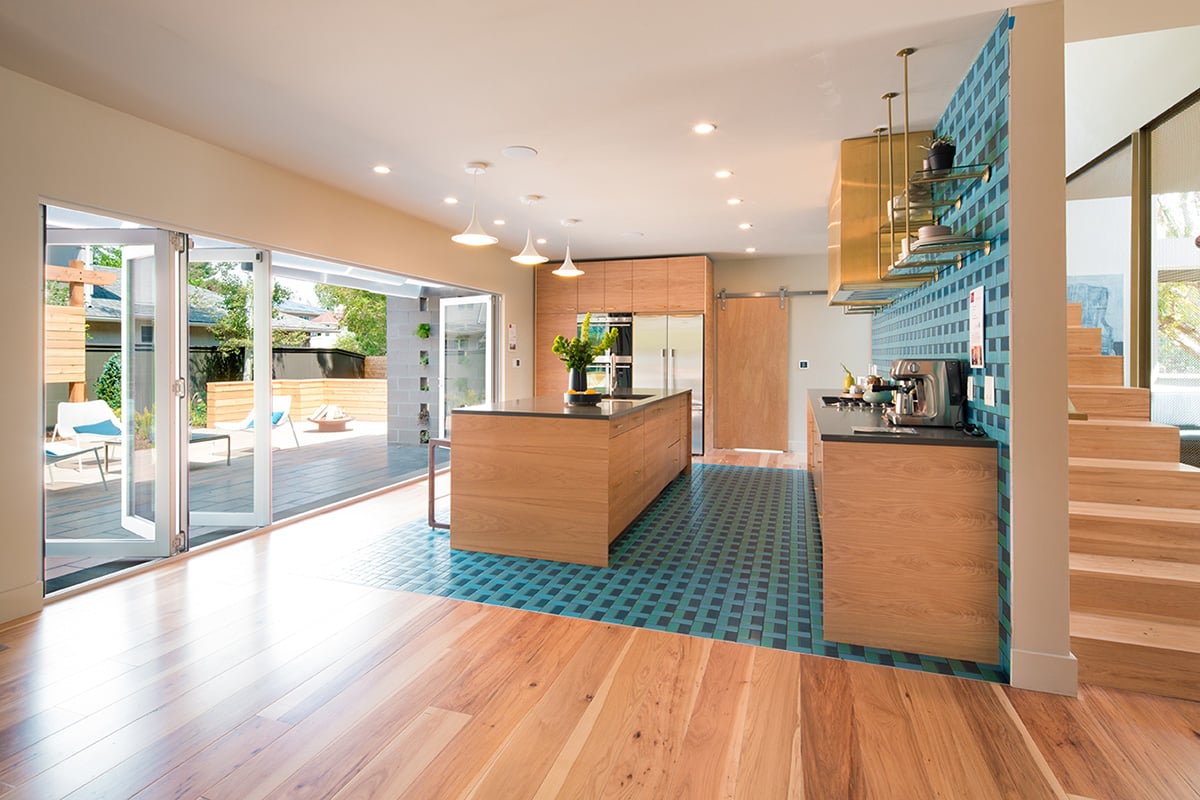 A wall-length bi-fold door opens to merge the kitchen with the patio.