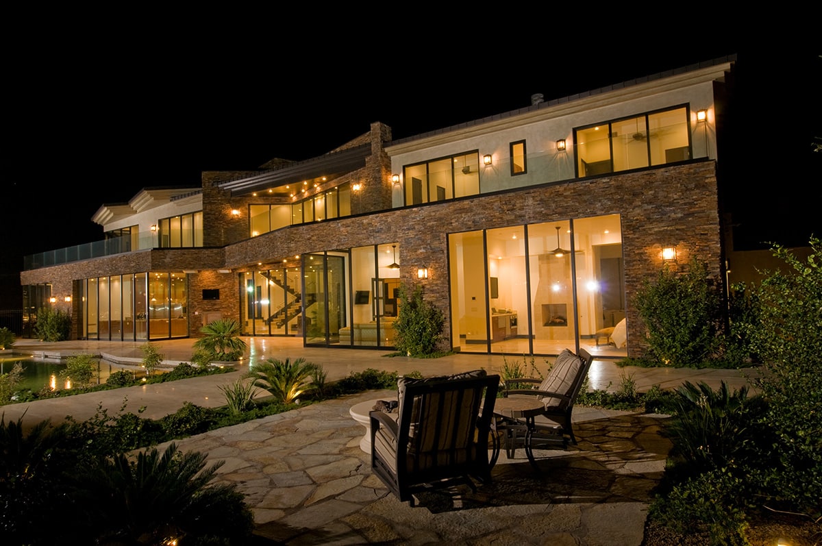 The home lights up the desert at night because of the numerous glazing on the back façade.