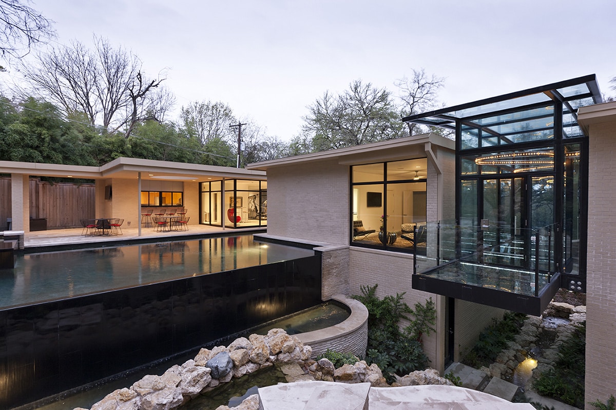 Massive panels of glass connect rooms in the home to the backyard.