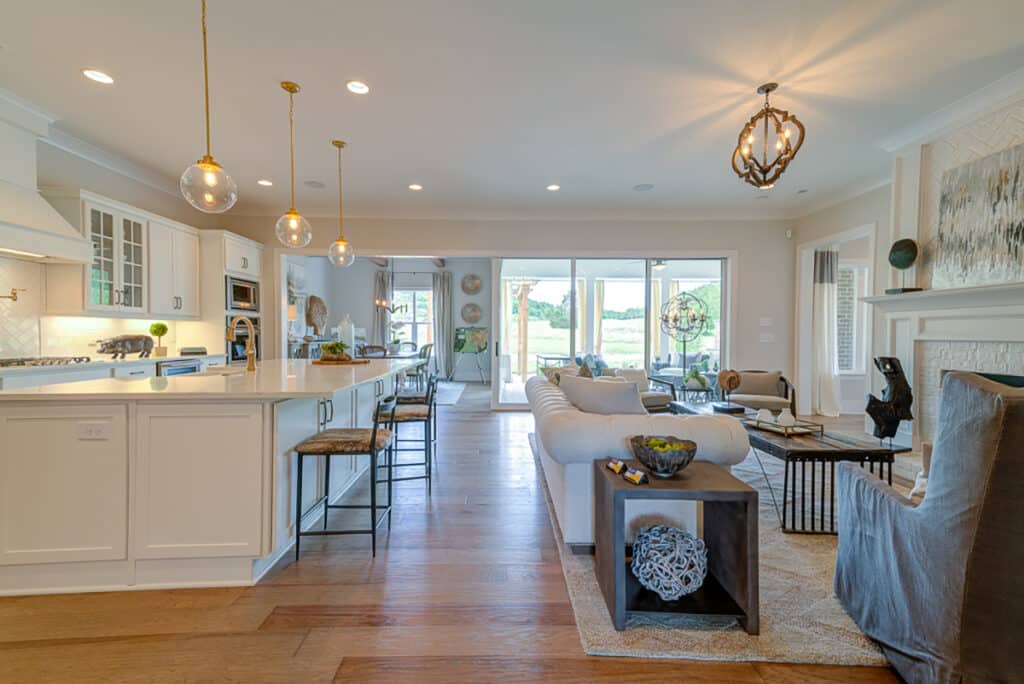 Tall, moving glass doors illuminate the kitchen and living room with sunlight.