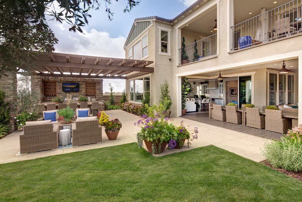 A covered outdoor living space blends with the indoors via multi-slide glass doors.