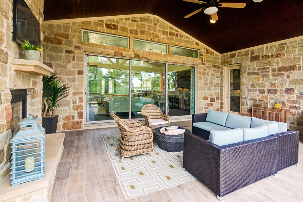 A large multi-slide glass door closes the outdoor seating area from the indoors.