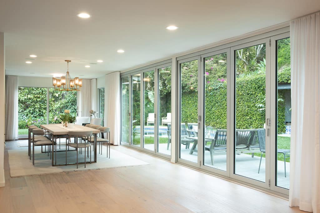 Two giant bi-fold doors completely open the living and dining spaces to the pool and outdoor patio.