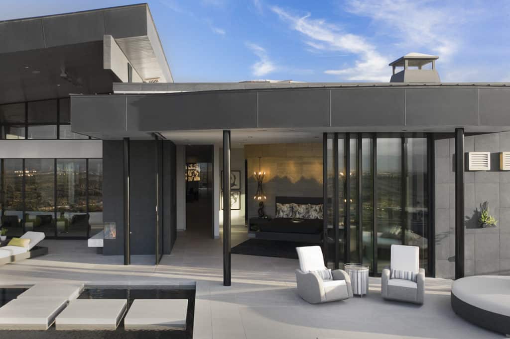 Giant moving walls of glass constitute virtually the entire back façade of the home, connecting rooms like the master bedroom to the patio.