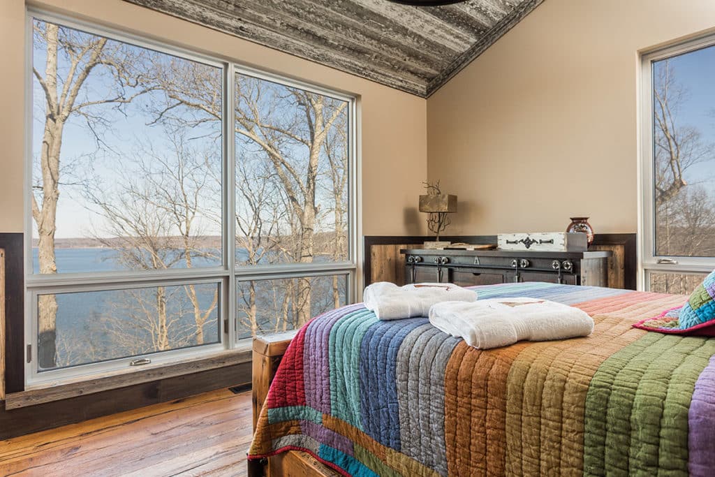 A combination of fixed and awning windows frame beautiful views of Lake Monroe from this bedroom.