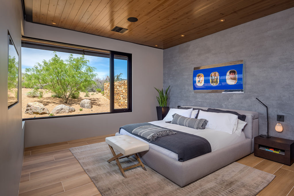 A 90-degree window and casement window invite desert views into this bedroom.