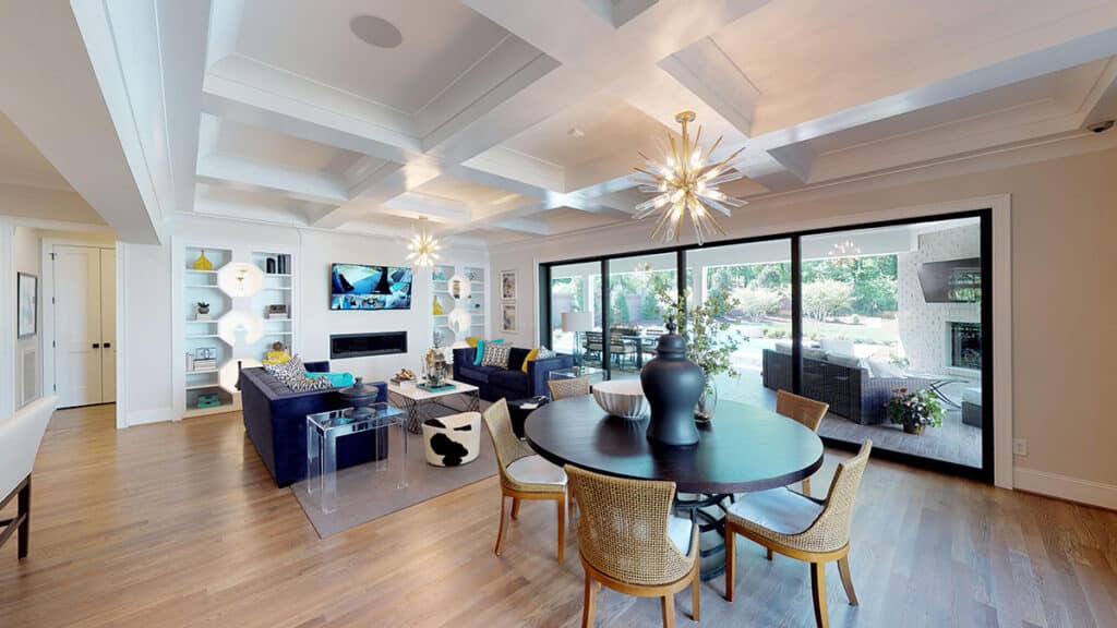 A living and dining room is separated from the backyard by a tall multi-slide glass door.