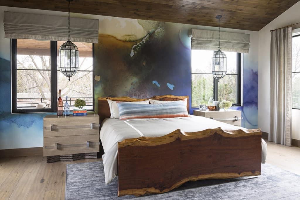 A divided lights windows sits on each side of a bed, each draped with valances at the top.