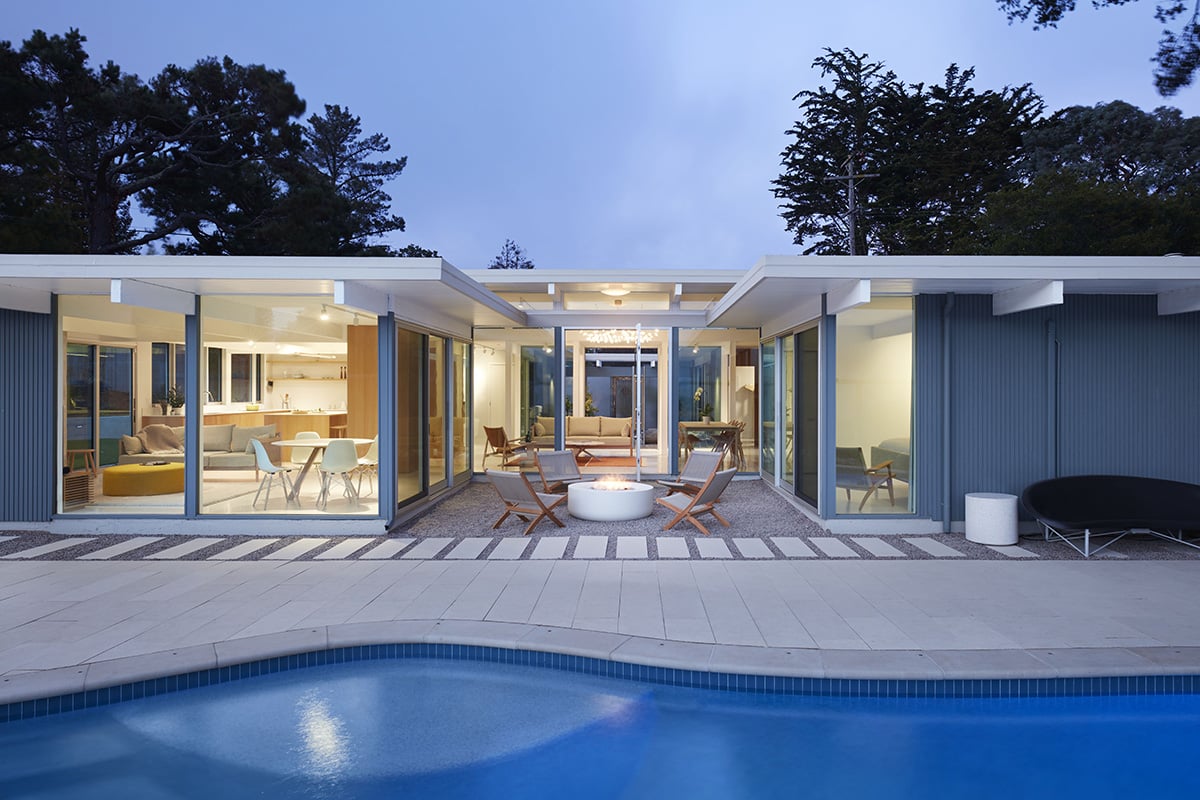 An open sliding door connect the outdoor seating area with the great room.