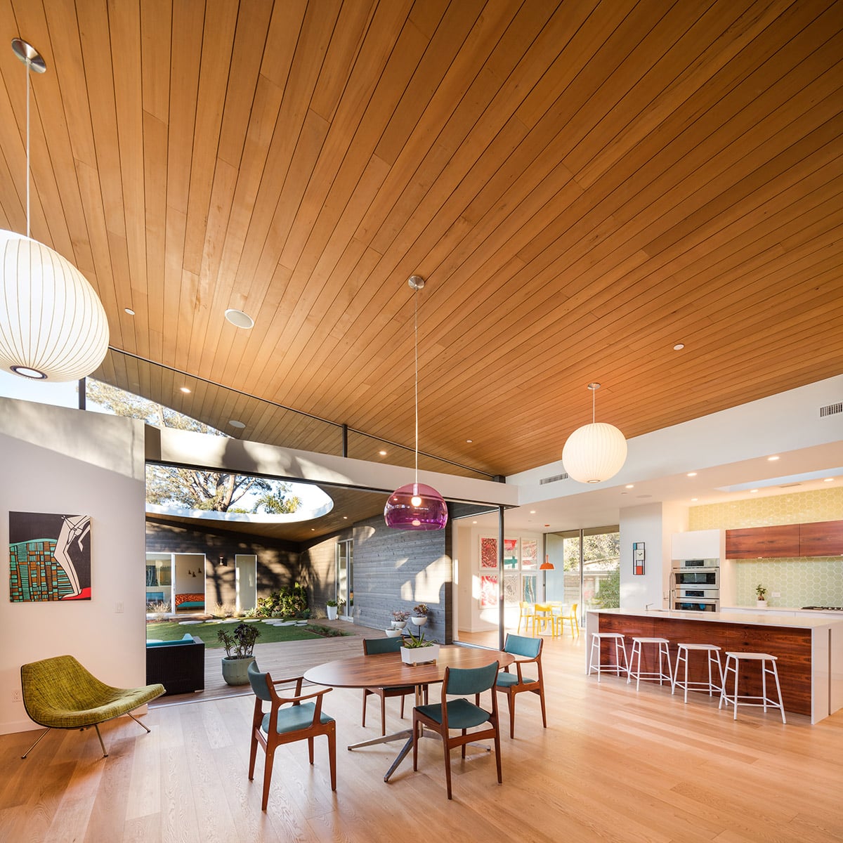 A large multi-slide door opens the colorful kitchen and dining area to the backyard.