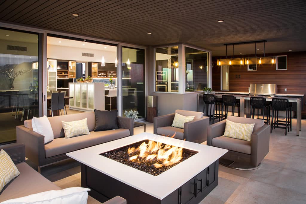 The outdoor living space cleanly transitions to the kitchen and dining room thanks to Western Window Systems’ moving walls of glass.