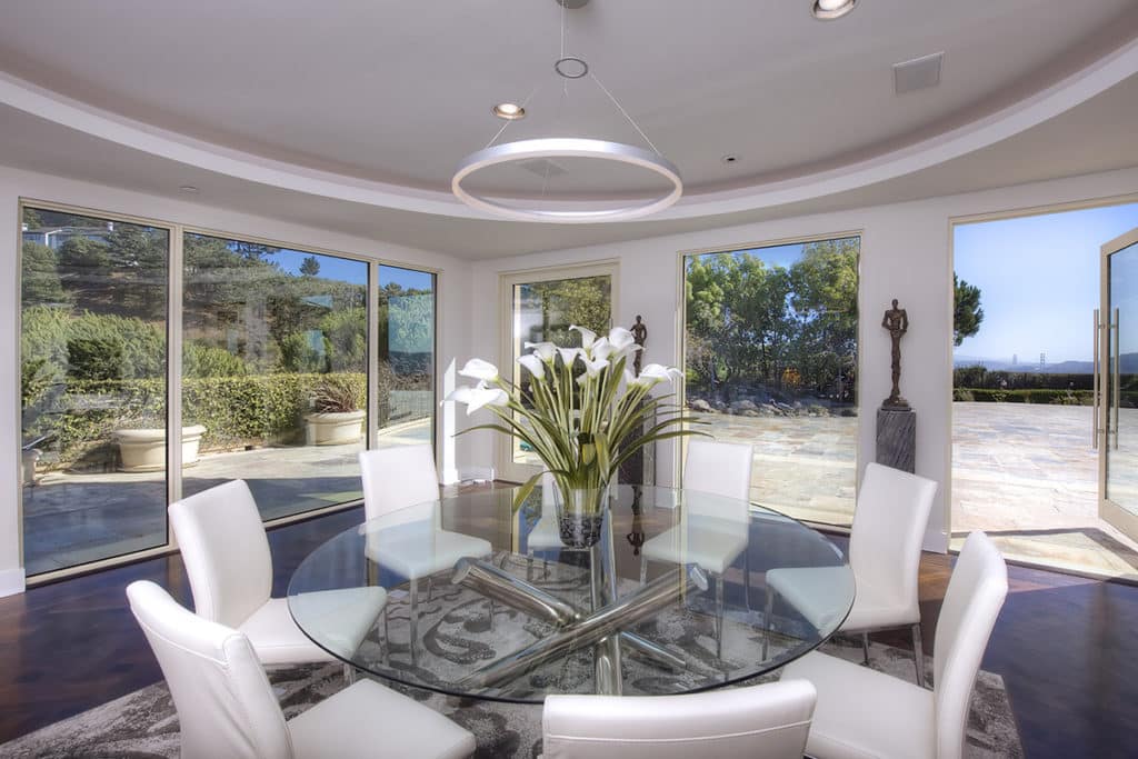 The dining room seamlessly merges with the back patio thanks to huge doors and giant windows from Western Window Systems that surround the dining table.