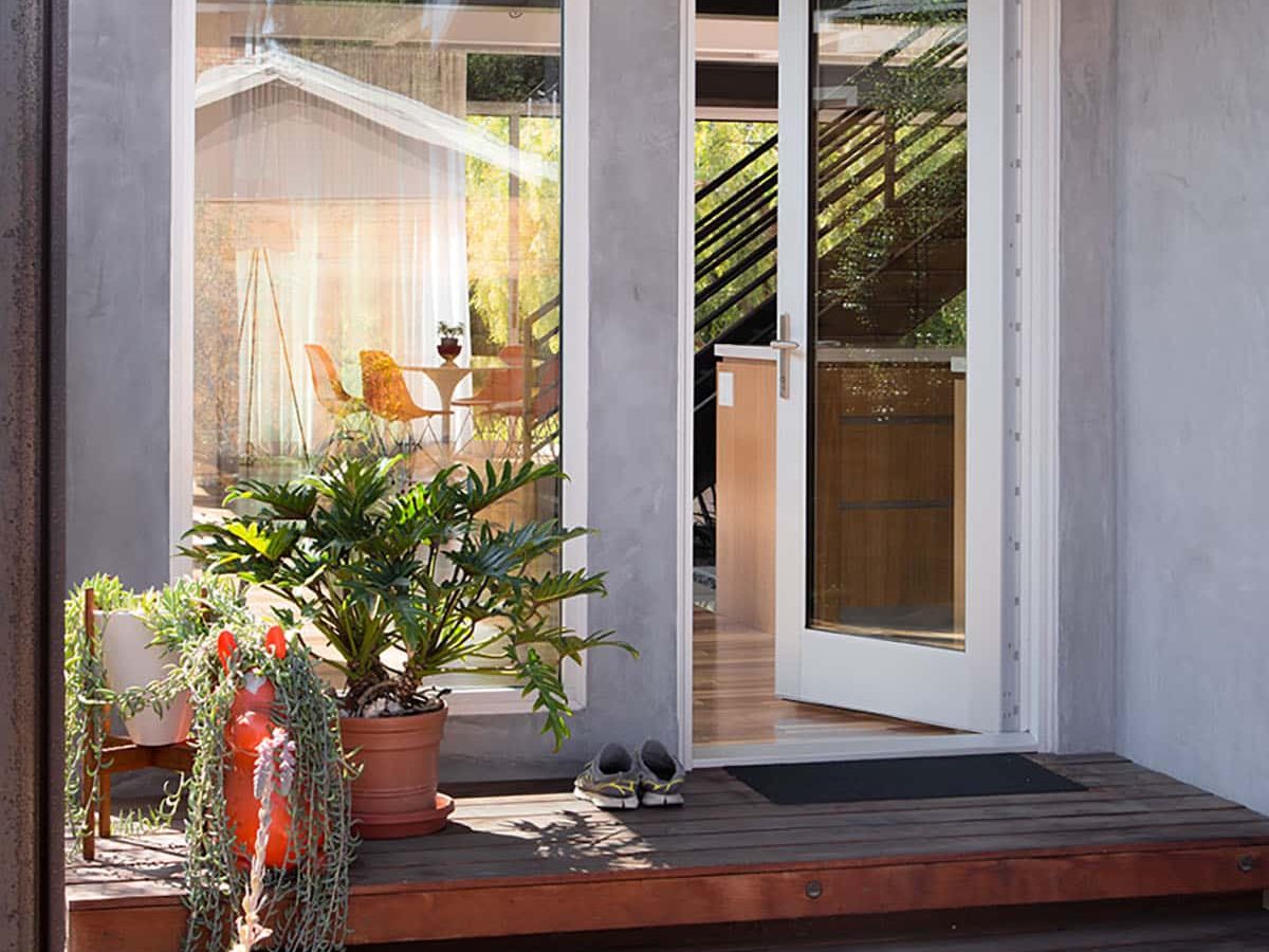 04-resica1602_160525_5d_0596_lr_170426final An open hinged door lends a modern aesthetic to the craftsman home next to a tall, fixed window.