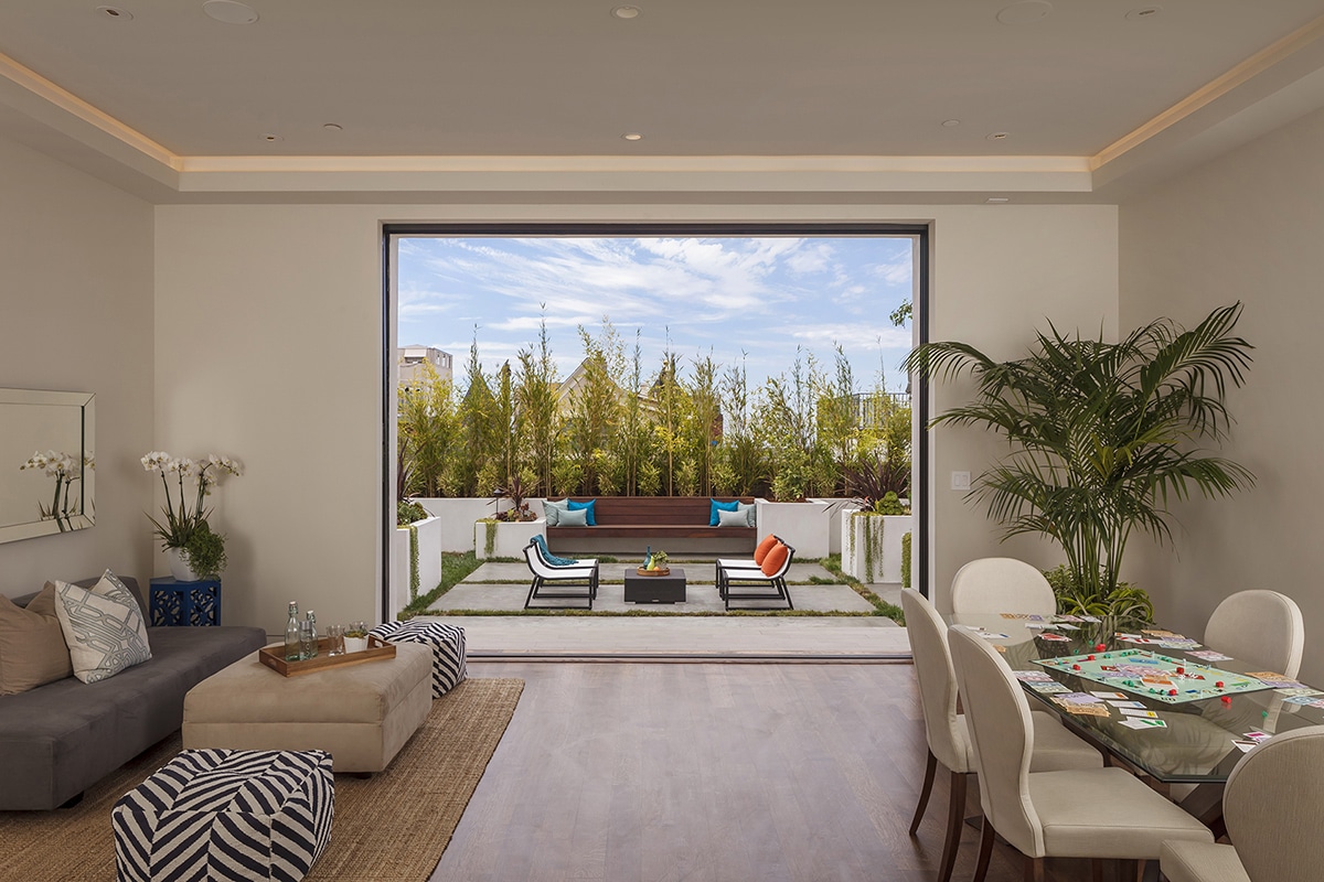 A large pocketing multi-slide door by Western Window Systems seamlessly transitions the first-floor living room to the backyard.
