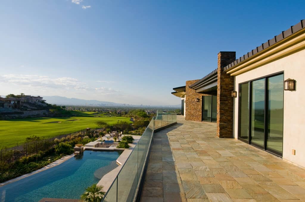 A view of the pool from the second-story balcony that connects to the home through multi-slide doors.