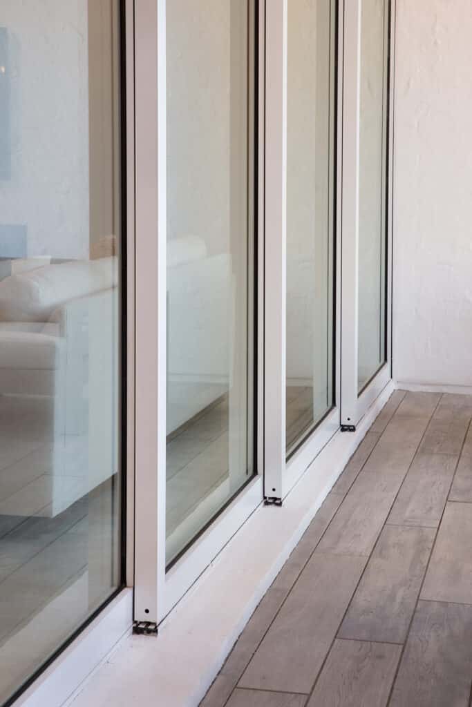 A close-up view of a multi-slide glass door’s bottom rail and tracks.