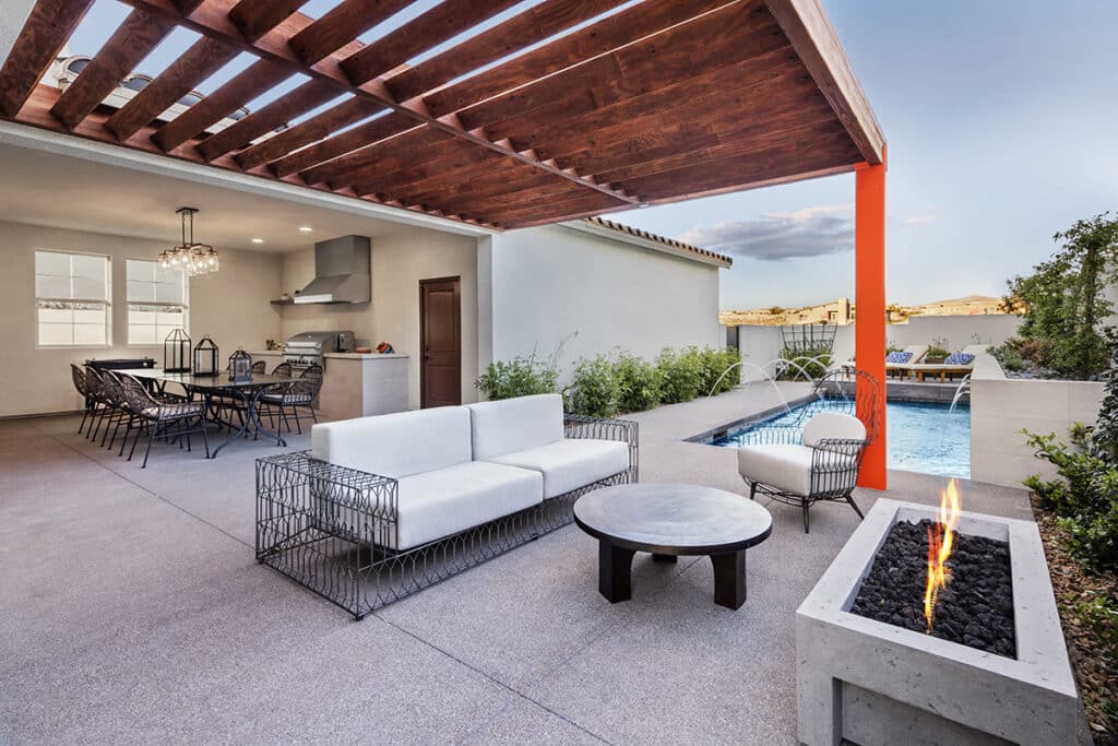 A view of a pagoda-covered outdoor living space and cooking area with a long pool.