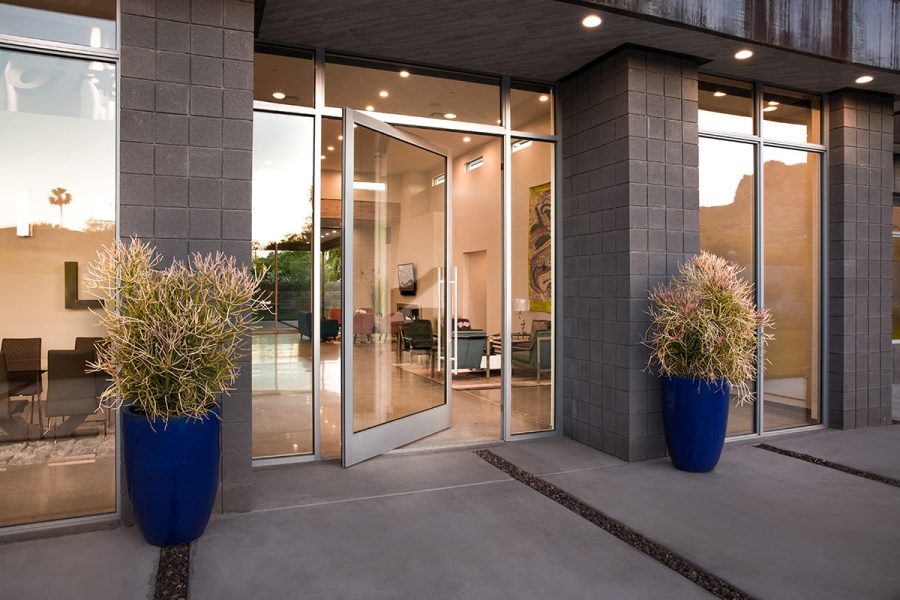 05-180419_6d_0078_lrpslr_180516final-mod A glass pivot door is surrounded by windows in an ultra-modern home.