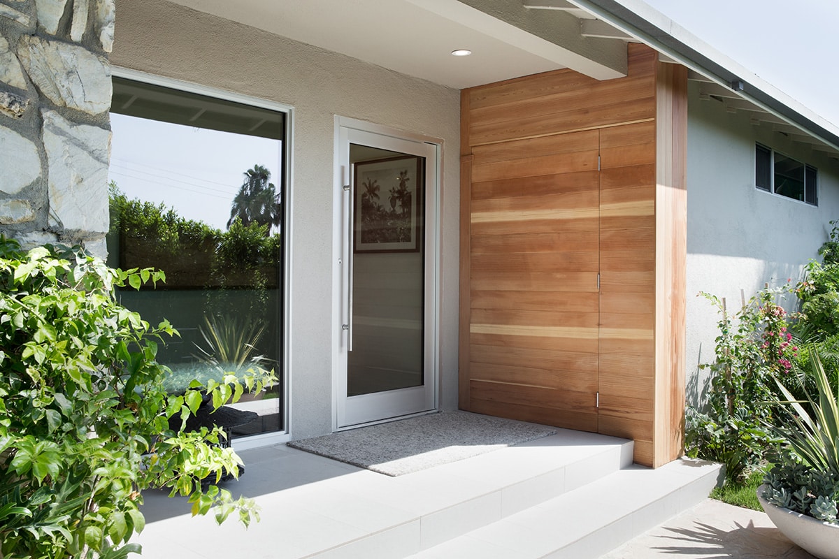 The front of the house is as beautiful as the back, with a pivot door and large fixed window.