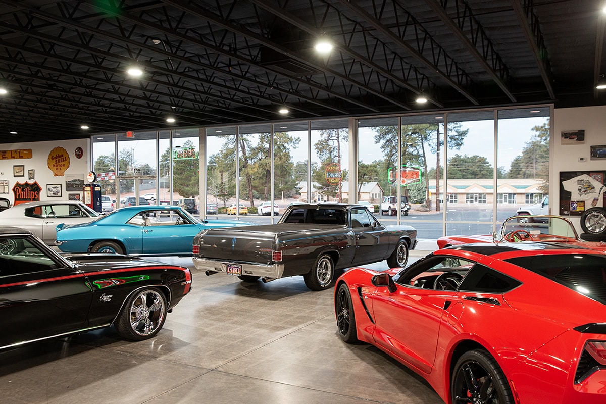 Giant moving walls of glass provide clear views of American muscle cars inside the showroom, and views of small-town Arizona outside the showroom.