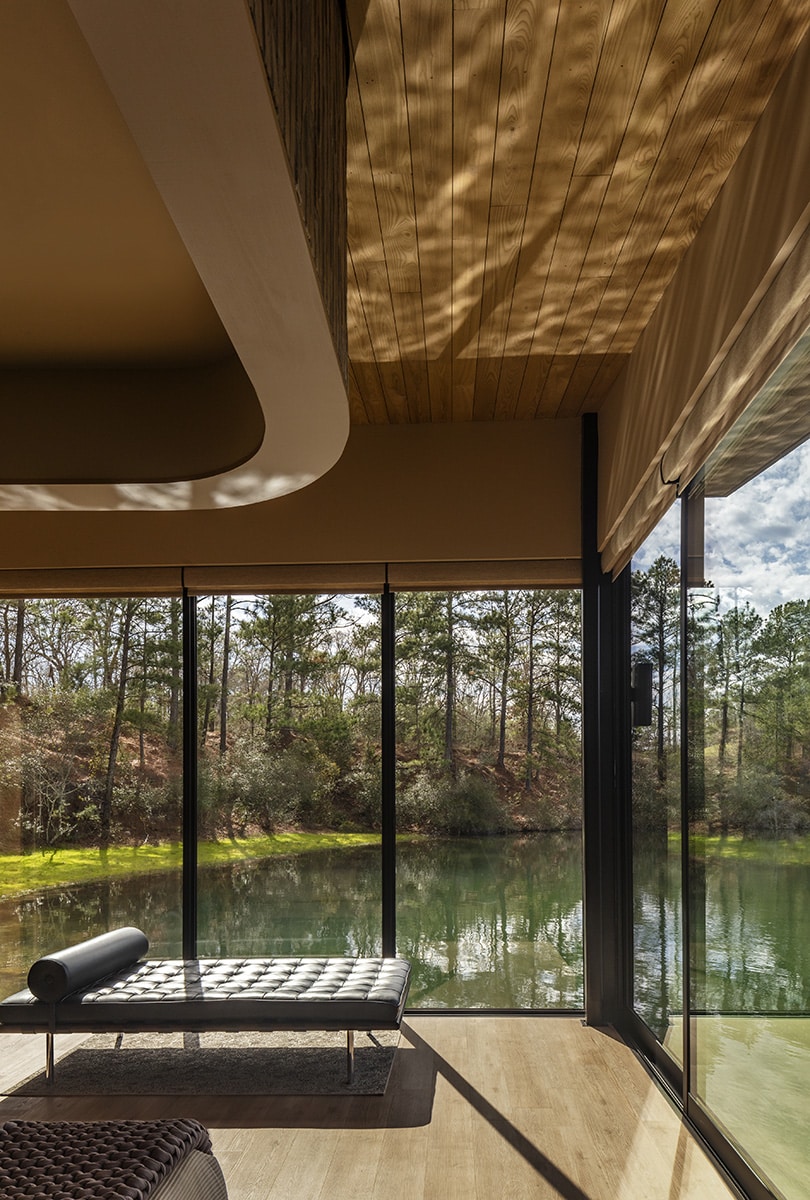 Light reflects on the ceiling of a glass-walled room.