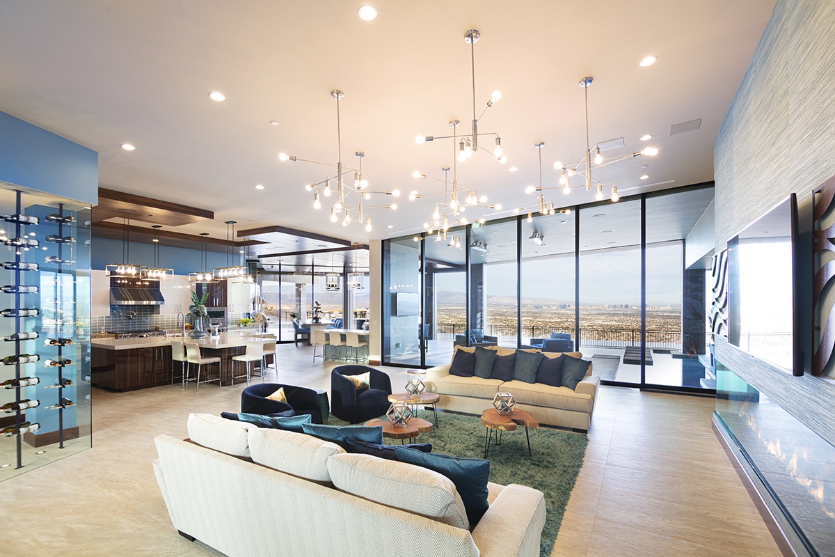 Walls of glass open the living room and dining room to the patio outside with views of the desert.