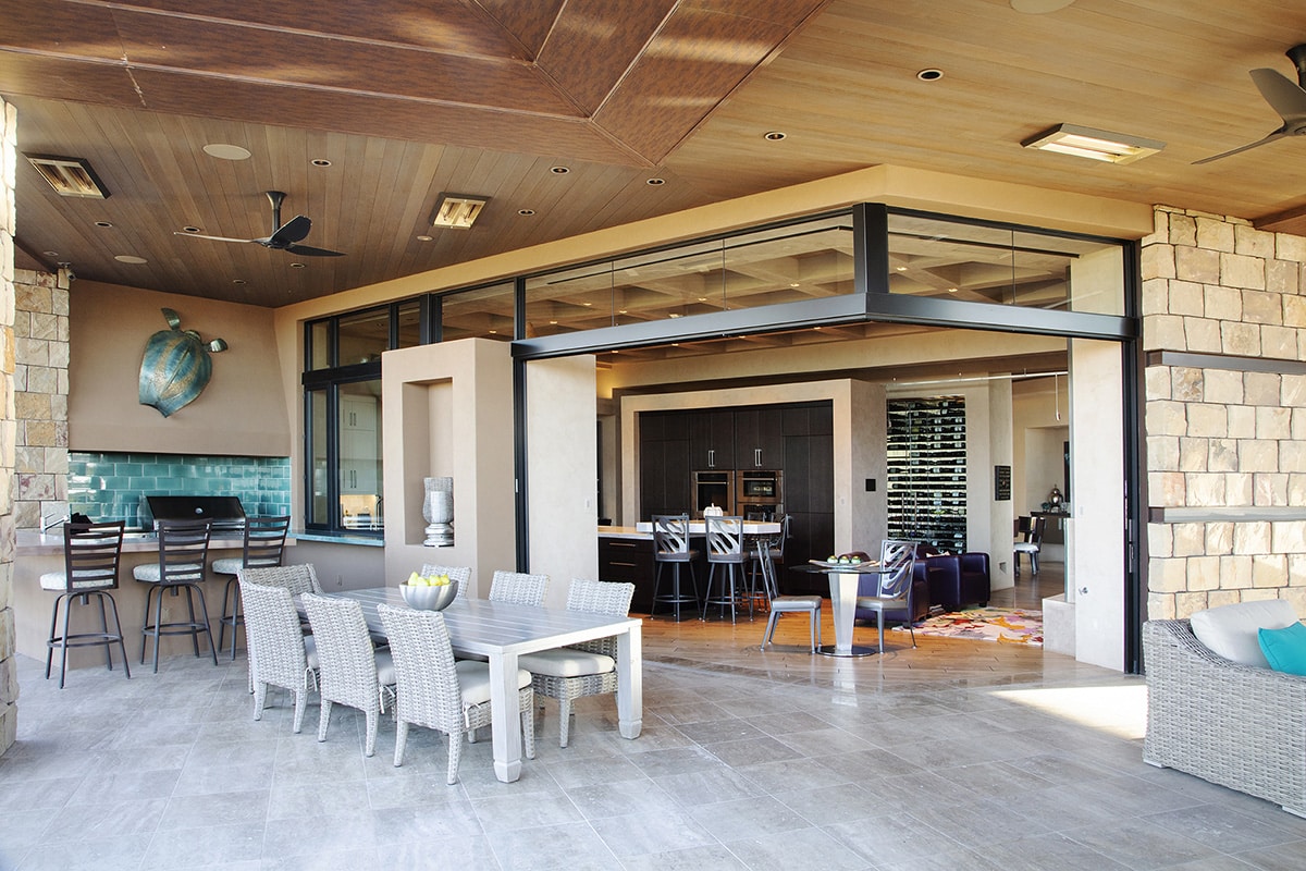 An open corner configuration of multi-slide doors creates an indoor-outdoor dining area.