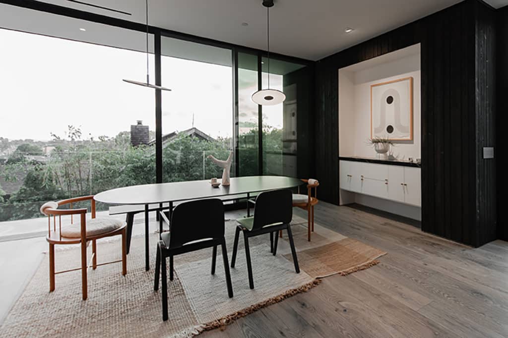 The dining area was placed upstairs to maximize views through floor-to-ceiling windows while preserving privacy from neighbors.