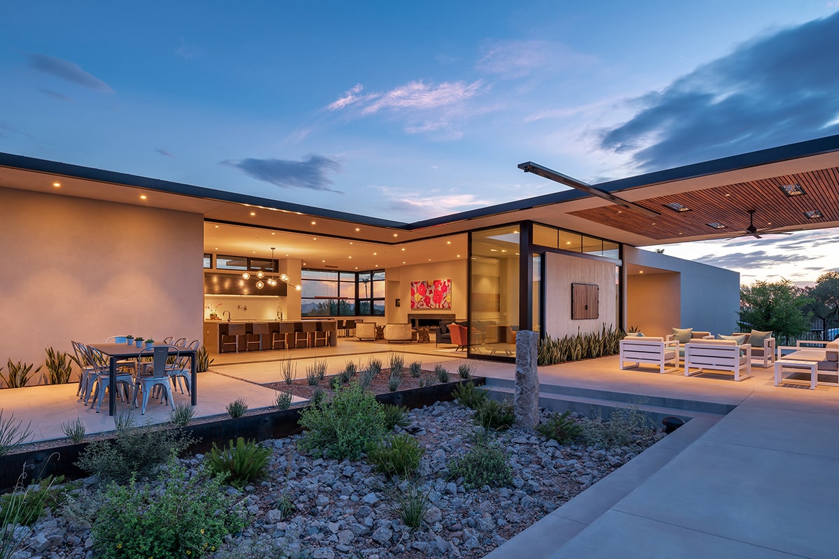 Desert plants and rock gardens augment the mountains in a picturesque setting outside of the open, 90-degree multi-slide doors.