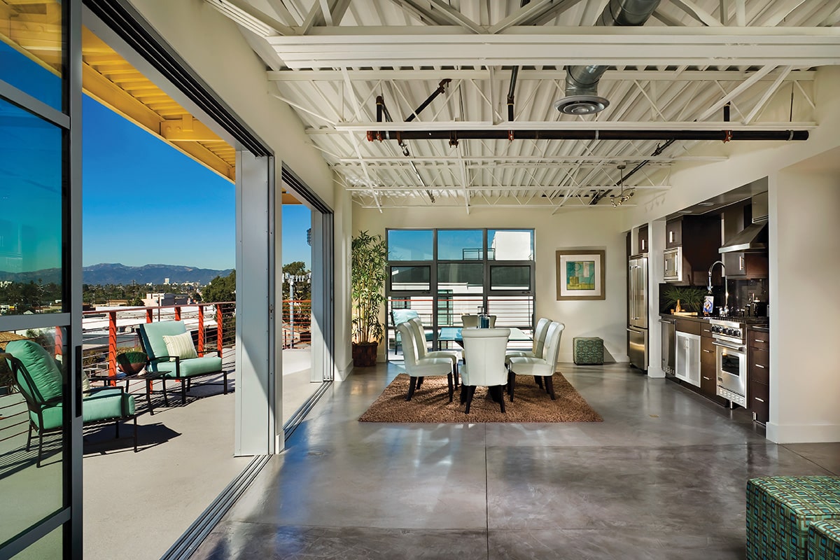 Multi-slide doors connect the kitchen to the balcony when open.