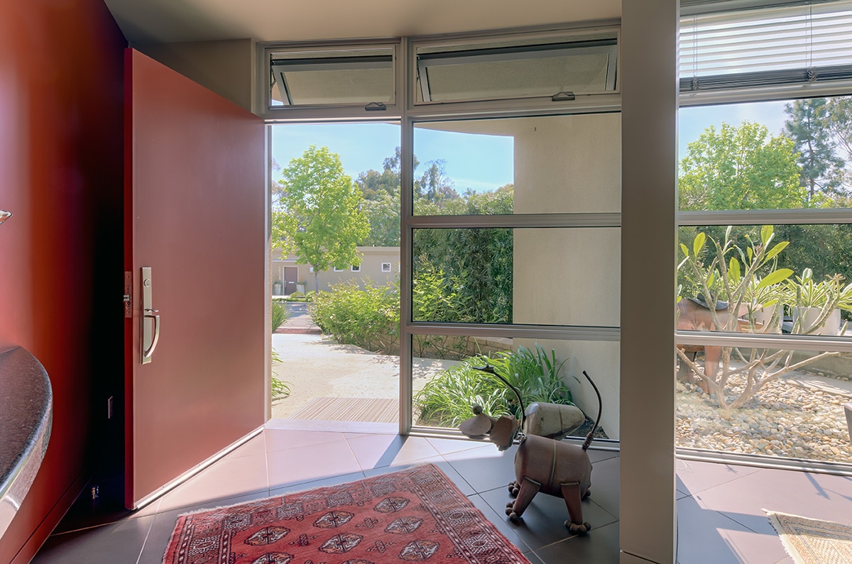 Western Window Systems hinged windows over the front door let fresh air into the home alongside the open front door.