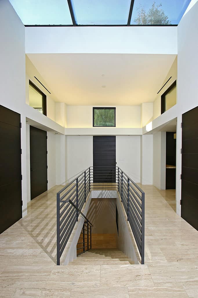 Clerestory windows sit above black doors and entrances to bring in natural light.