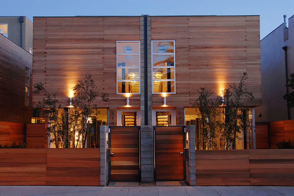 A front view of two homes side-by-side with mirrored, vertical 4 pane windows on the second floor.