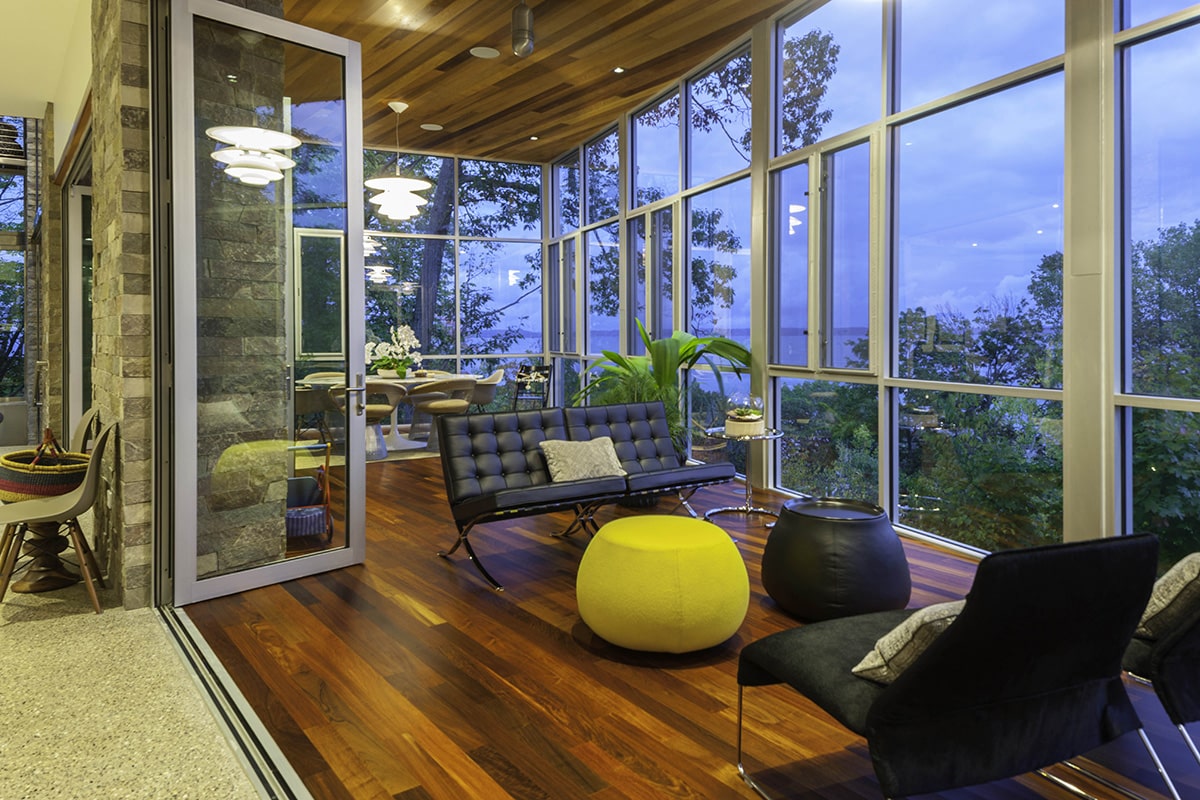 This enclosed porch is as tasteful and elegant as the white-framed windows completely surrounding it.