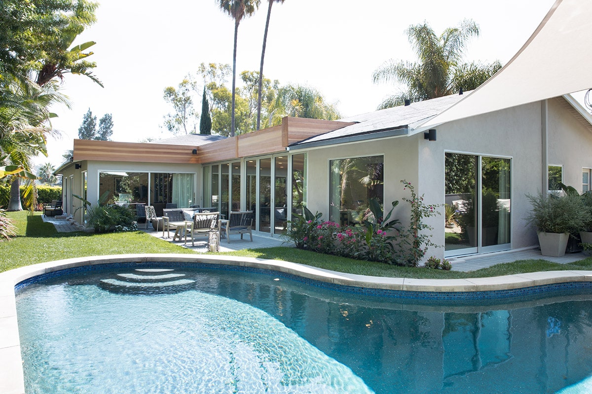 Large glass windows create an inviting space to the backyard and pool on the exterior of the home.