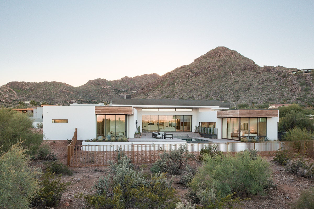A rear view of the home with numerous glass walls.