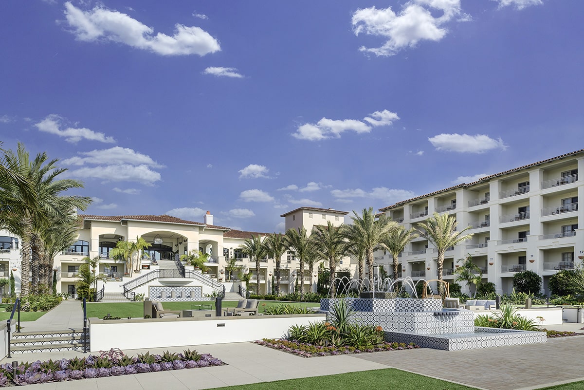 A front view of the luxury with a grand staircase and a water fountain.
