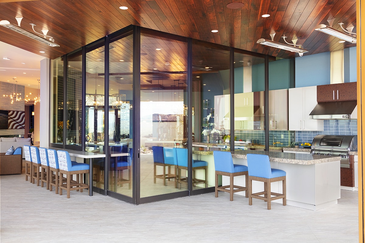 The architect designed multi-slide doors that go through the center of the kitchen island to completely open up the entertainment area.